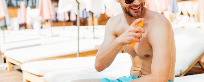 Man Applying Sunscreen By The Pool