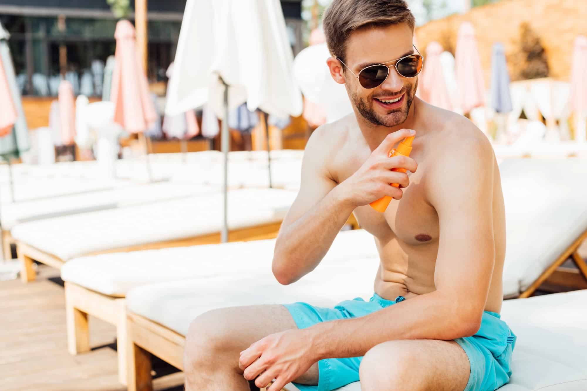 Man Applying Sunscreen By The Pool