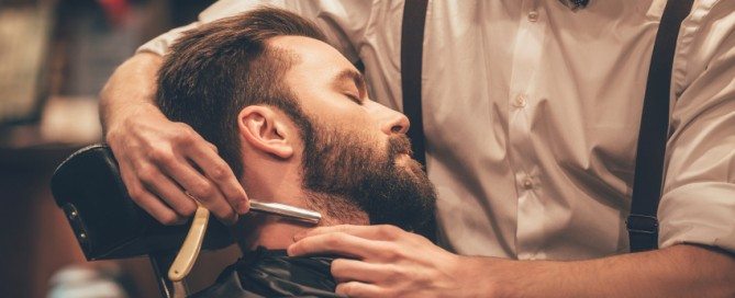 Man getting a beard trim by barber in Carmel