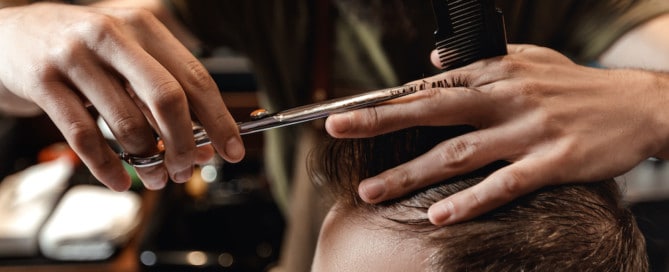 Stylist Giving Man A Haircut In Barbershop